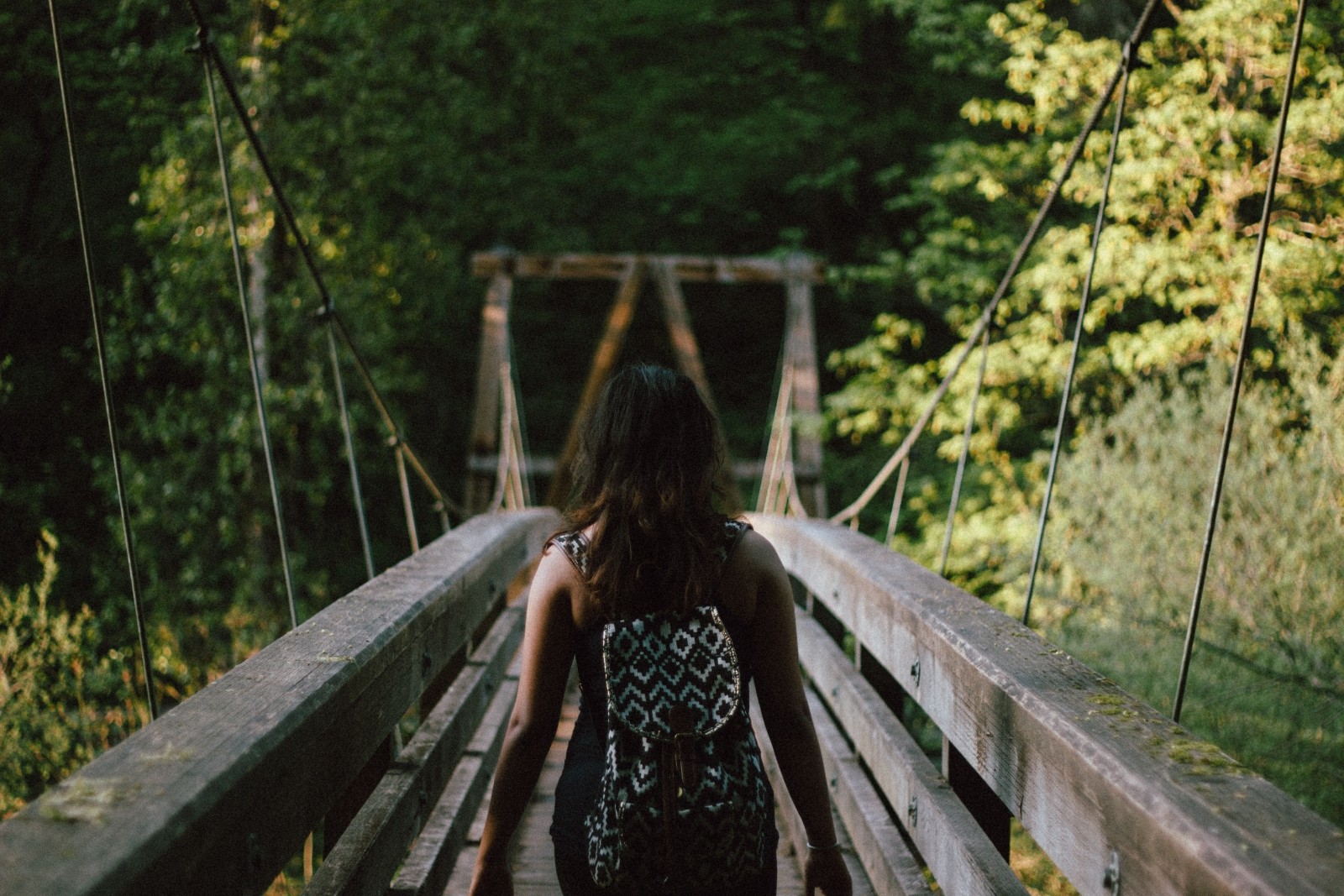woman-walking-on-bridge-in-forest